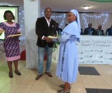 Commissioner for Youth and Sports presenting a certificate to Rev. Sr. Scholastica Okonkwo