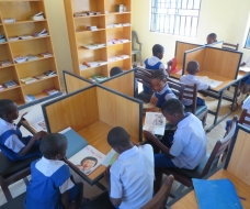 SCHOOL PUPILS IN LIBRARY STUDING PRESENTED BOOKS